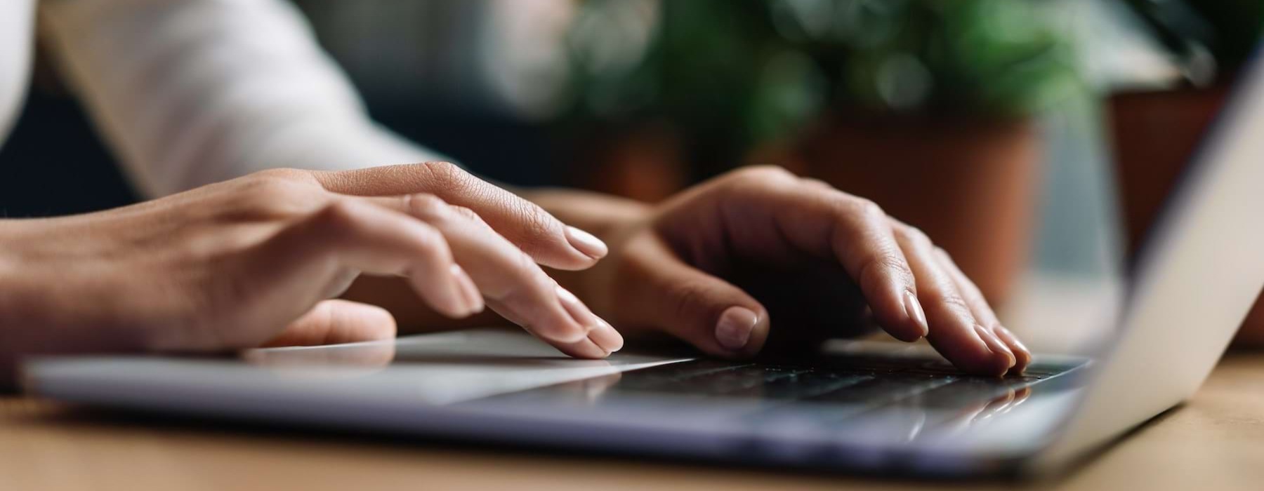 A person typing on a laptop at a desk at The Preserve at Travis Creek Southwest apartments Austin.