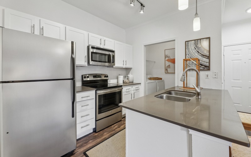 a kitchen with stainless steel fridge, microwave, and stove