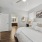 A room with a bed, nightstand, dresser and bathroom